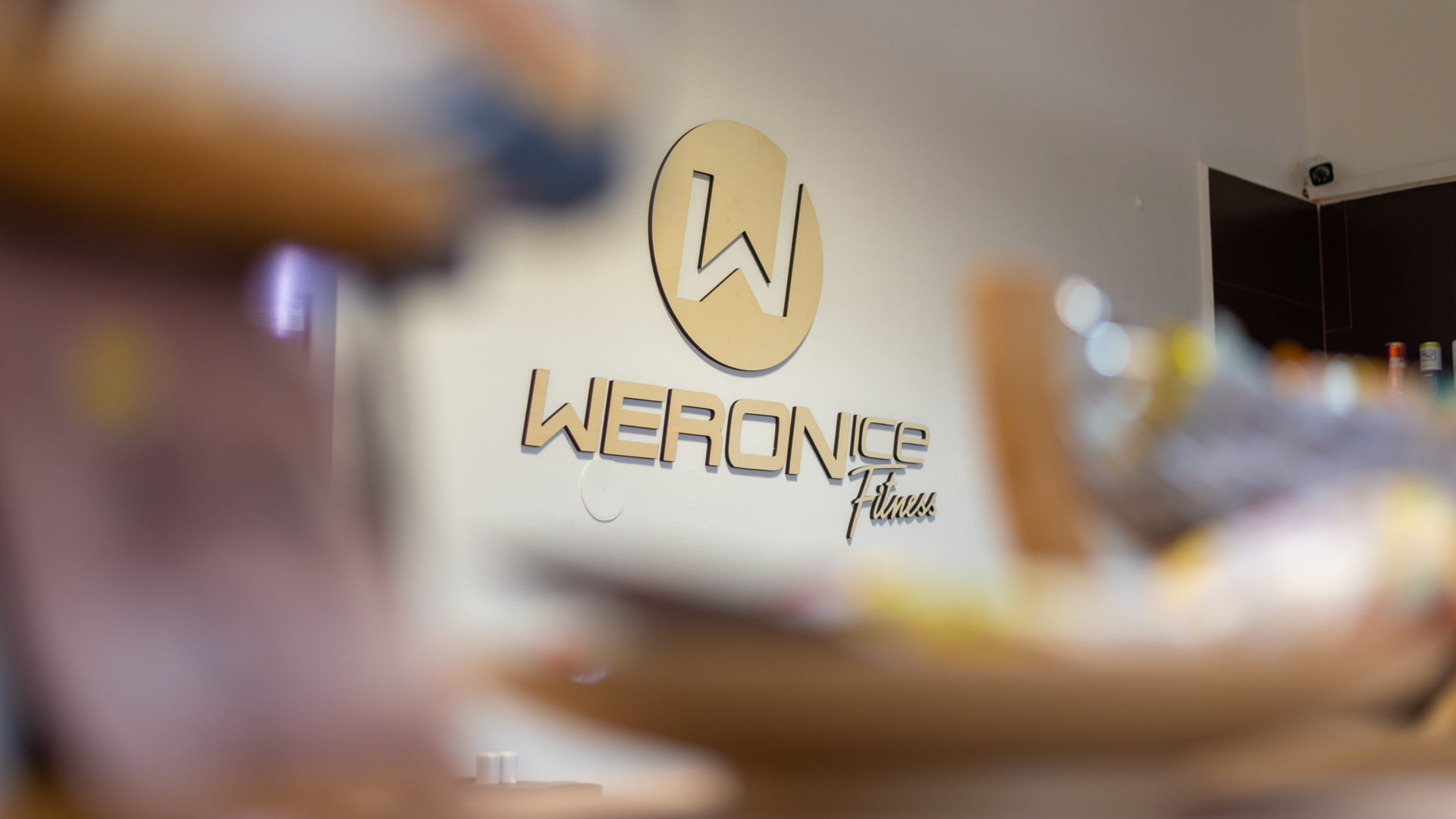 Drevené logo Weronice Fitness na stene