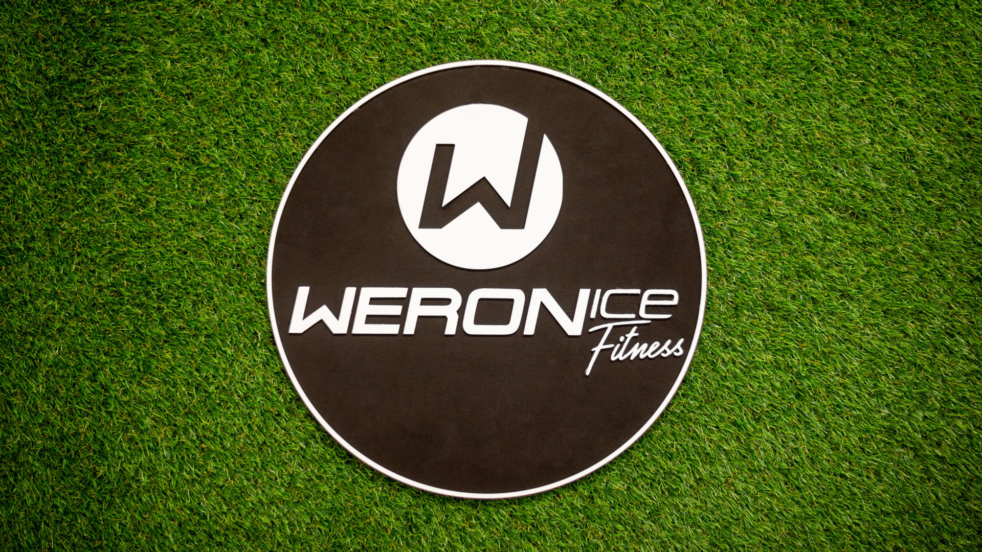 Logo Weronice Fitness na trávnatom podklade